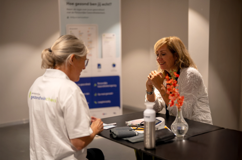 Medewerker van Niped voert gezondheidsmetingen uit op het checkpoint
